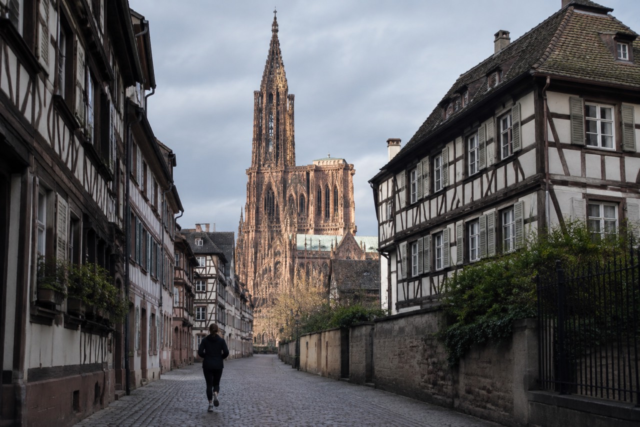 Illuminated Strasbourg Cathedral rising above dark rooftops at night