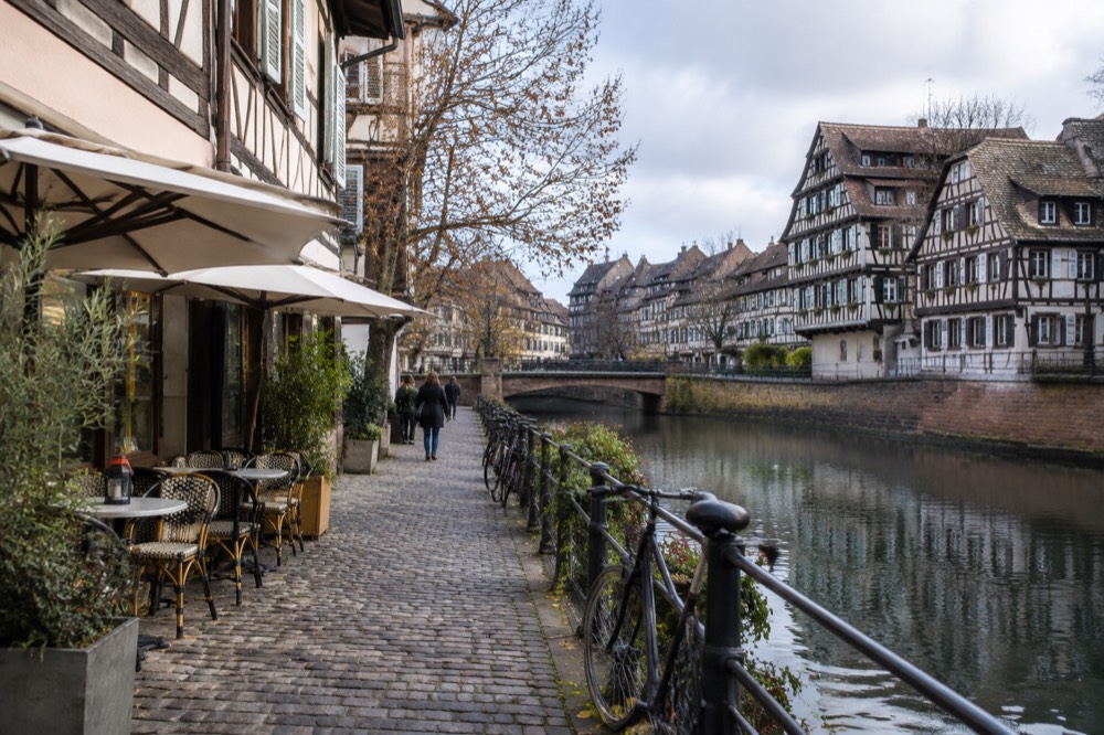 A cobbled lane with bar signs in the Krutenau quarter of Strasbourg at dusk