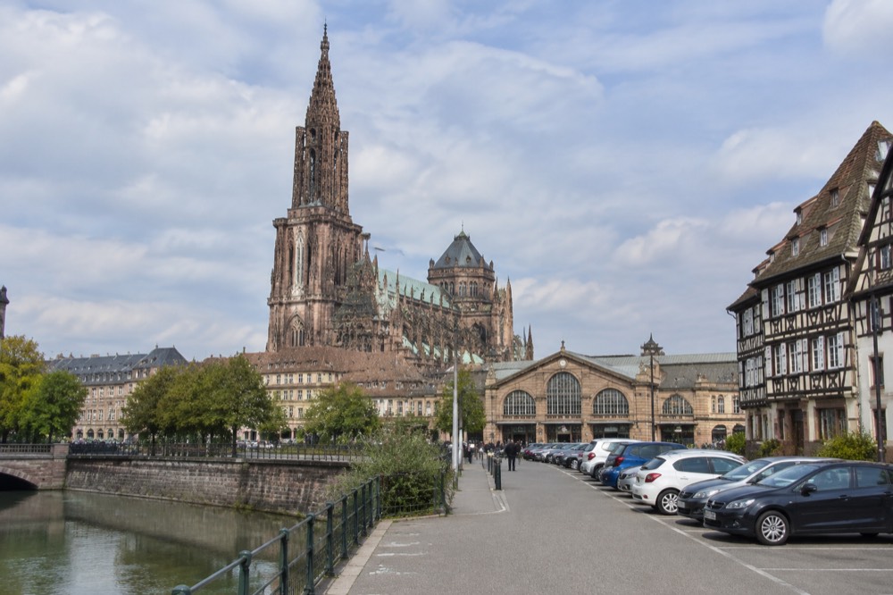 Rental cars lined up in a station-side car park with the Strasbourg station facade beyond