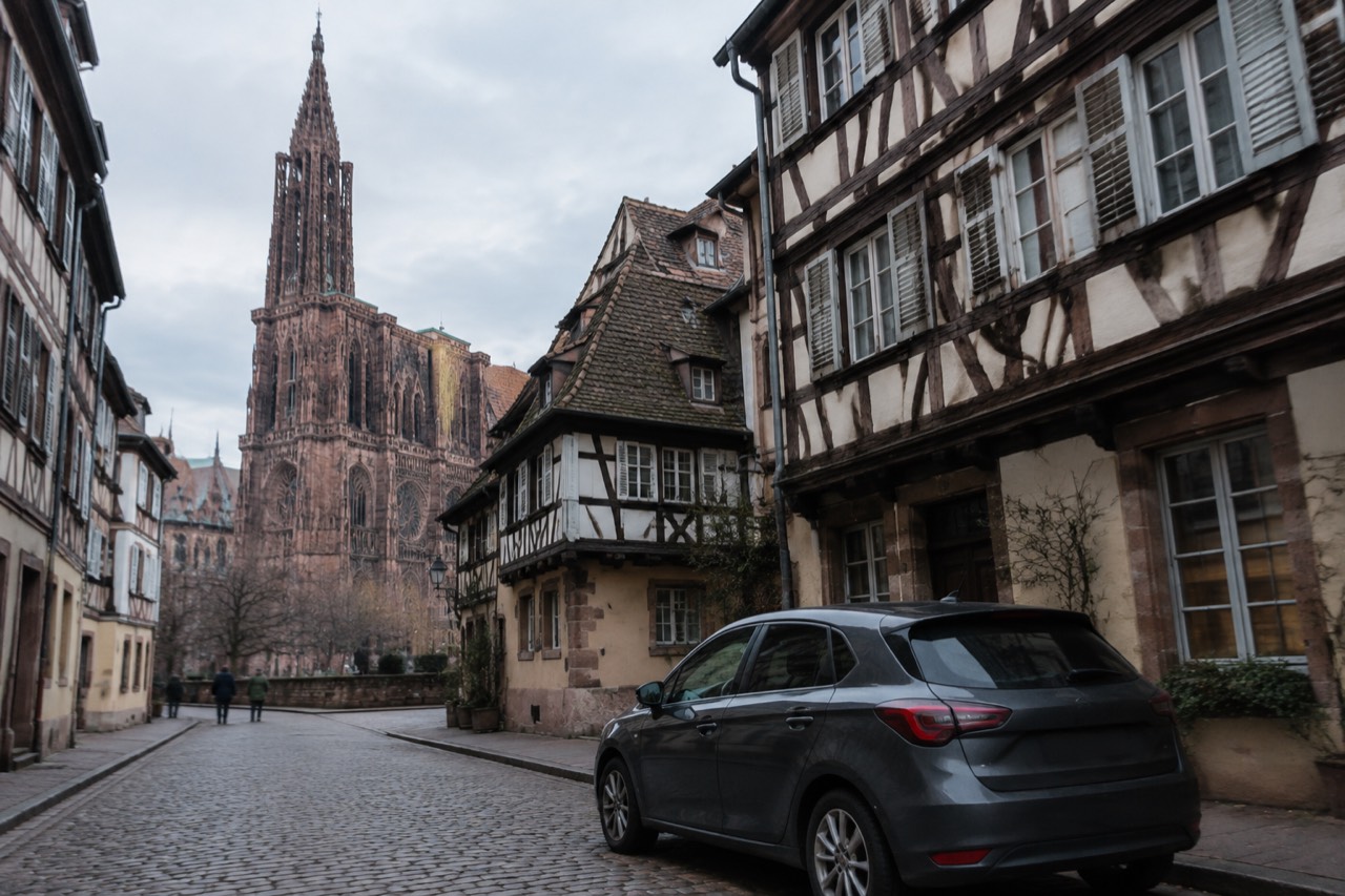 A hire car parked on a quiet Strasbourg street with half-timbered buildings behind it