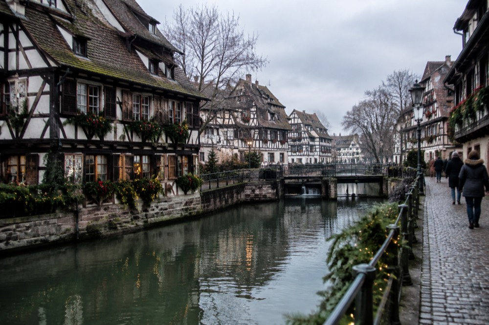 Half-timbered houses along a canal in Petite France decorated for Christmas