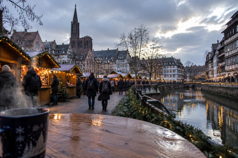 Half-timbered houses and canal reflections with Christmas lights in a riverside quarter