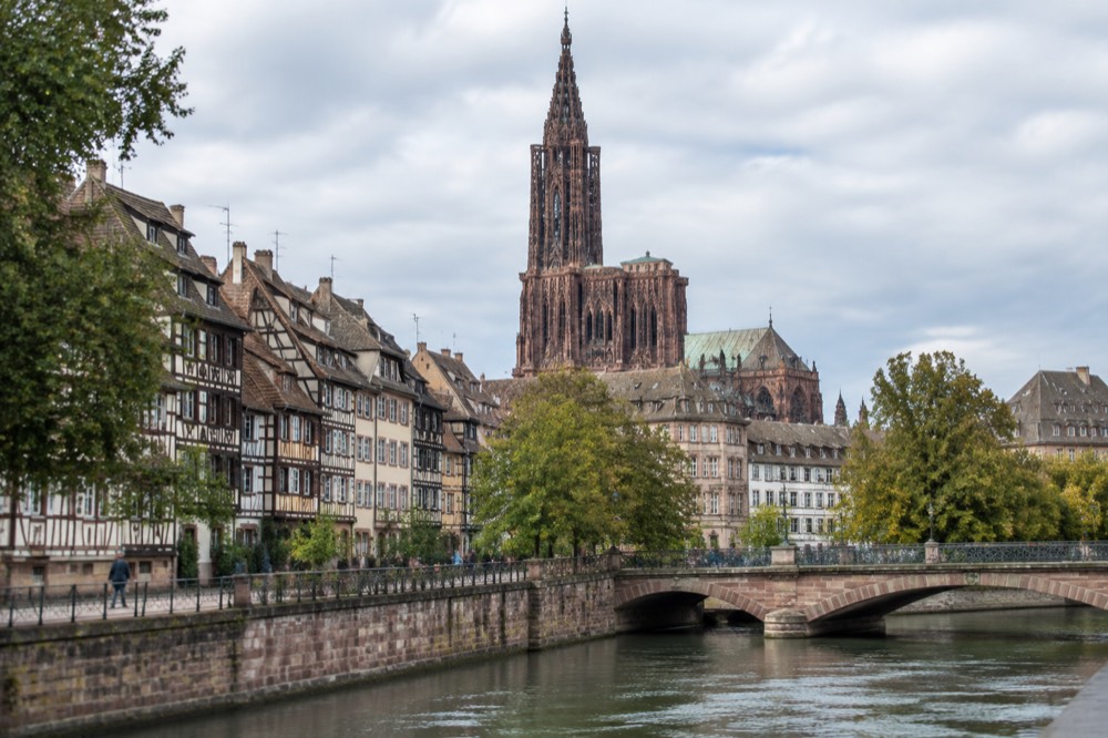 Stone bridge and riverside trees along the Ill in Strasbourg