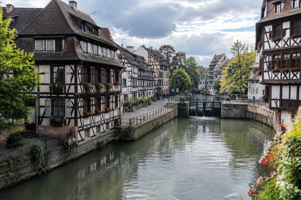 Half-timbered houses along a canal in Strasbourg's Petite France quarter on a bright morning