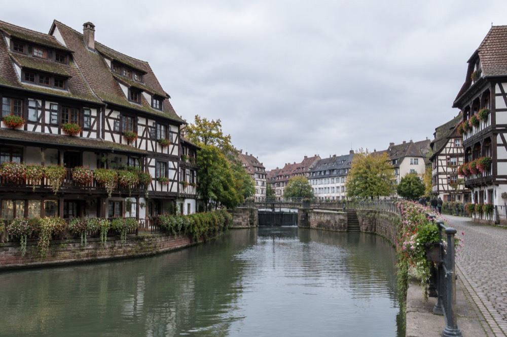 Flower-covered balconies on timber-framed buildings beside the Ill river in Petite France