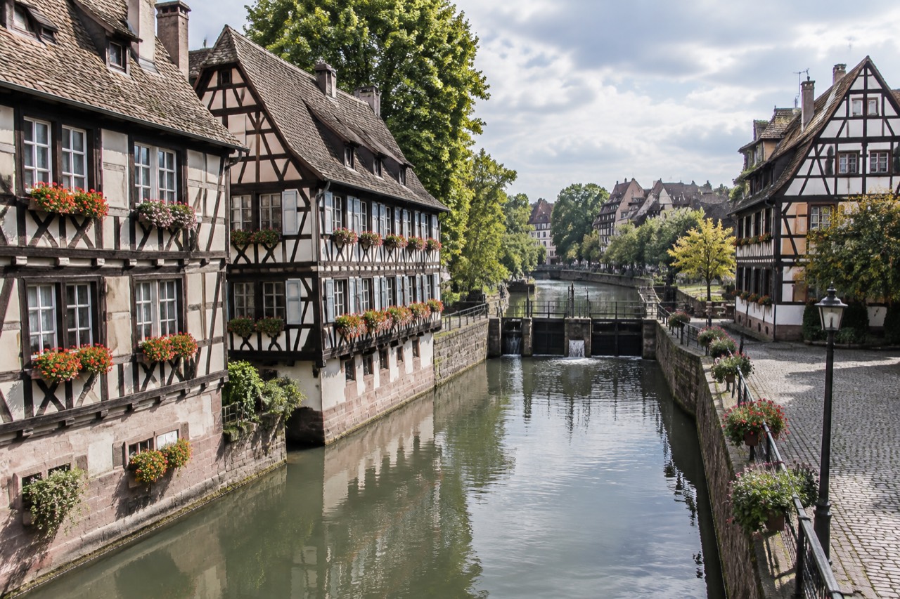 Half-timbered houses along a canal in Strasbourg's Petite France quarter on a bright morning