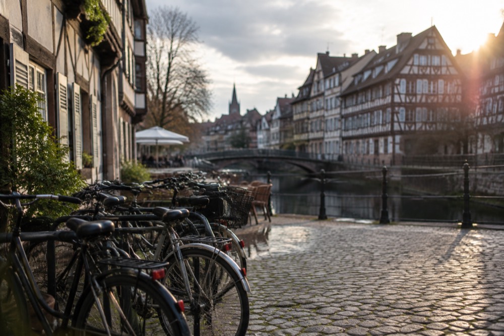 A row of bicycles parked on a cobbled square beside half-timbered houses