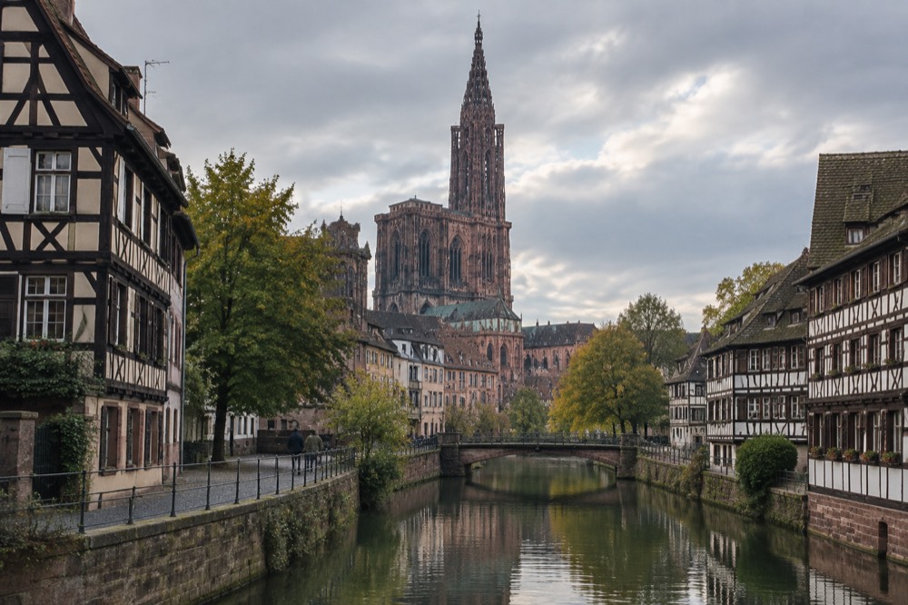 A quiet canal in Strasbourg lined with half-timbered houses and reflections in still water