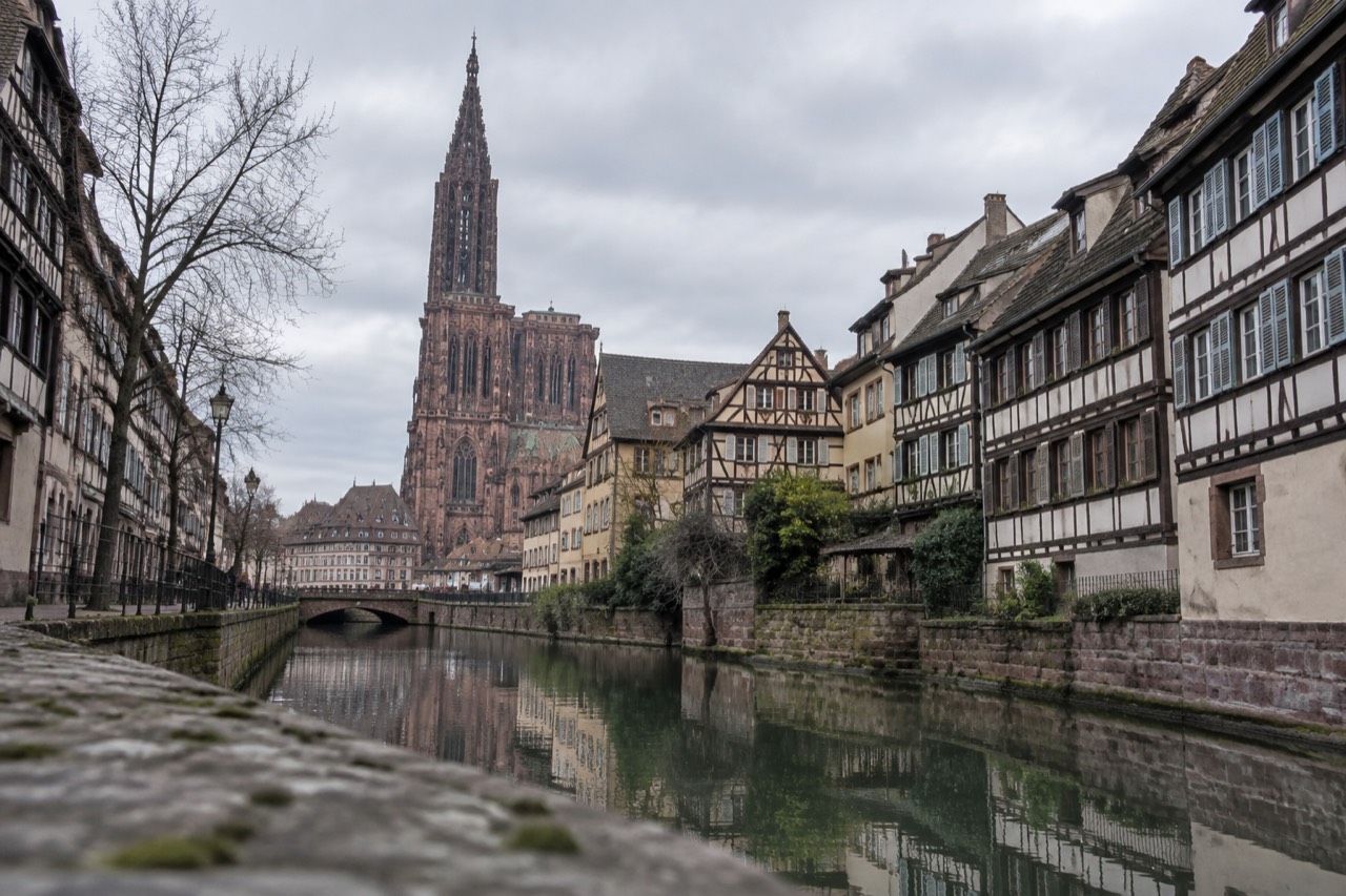 A quiet canal in Strasbourg lined with half-timbered houses and reflections in still water