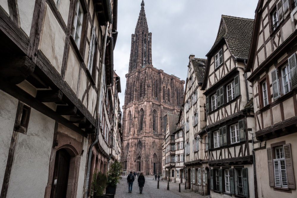 Narrow medieval lane with timber-framed houses leading toward the cathedral
