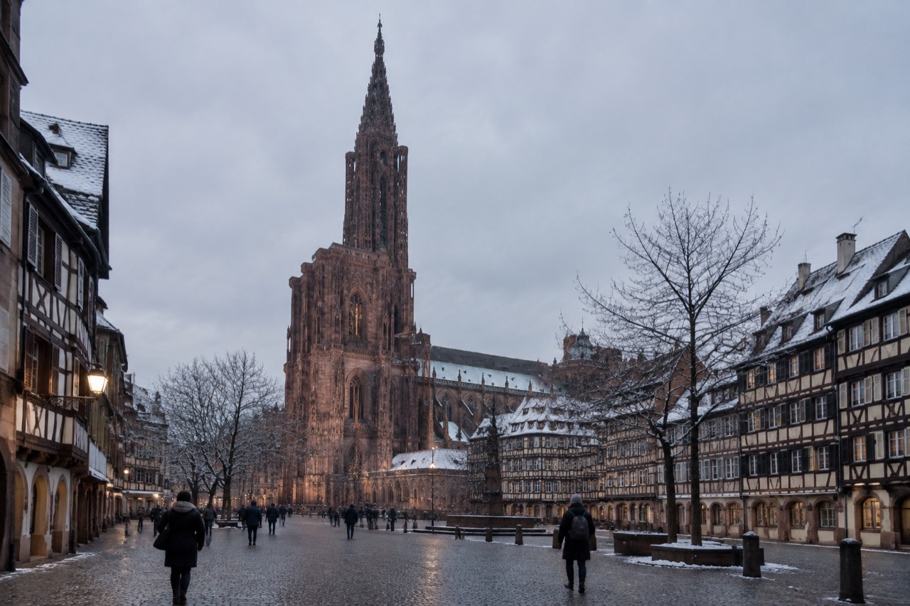 Strasbourg Cathedral rising above snow-dusted rooftops at dusk