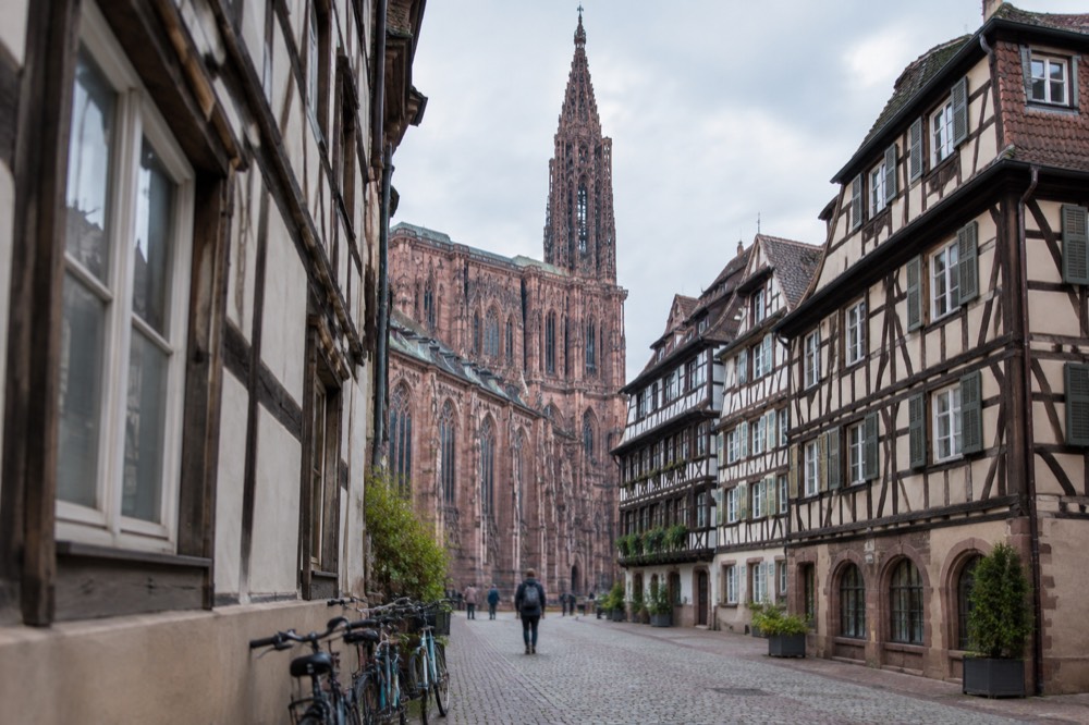 A quiet street of half-timbered buildings in central Strasbourg with bicycles leaning against a wall