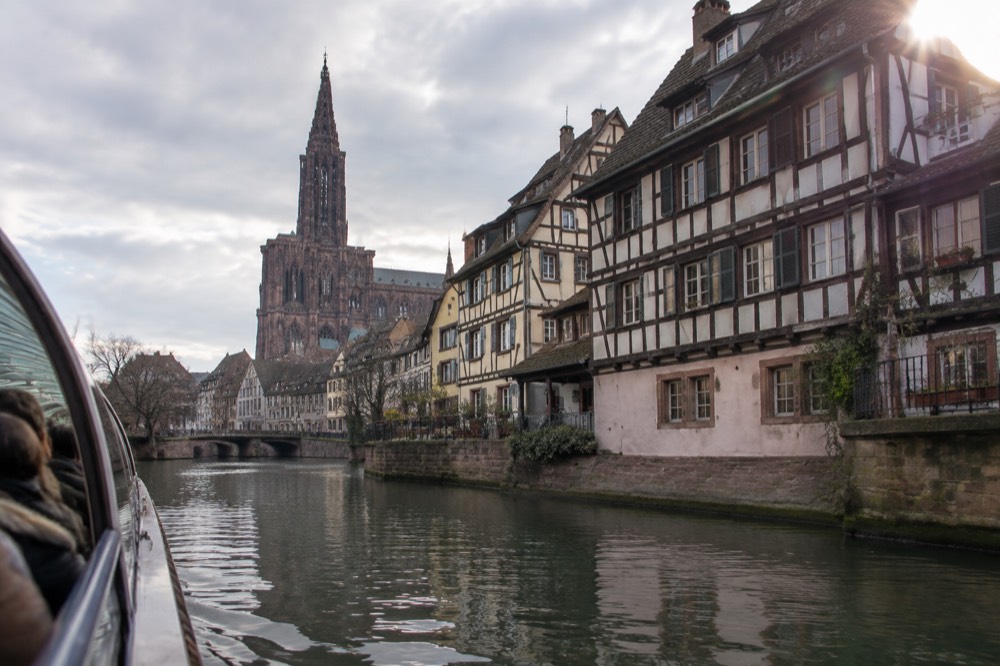 A river boat passing half-timbered houses along the Ill in Strasbourg