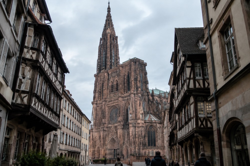 Strasbourg Cathedral's Gothic west front rising above narrow old streets in morning light