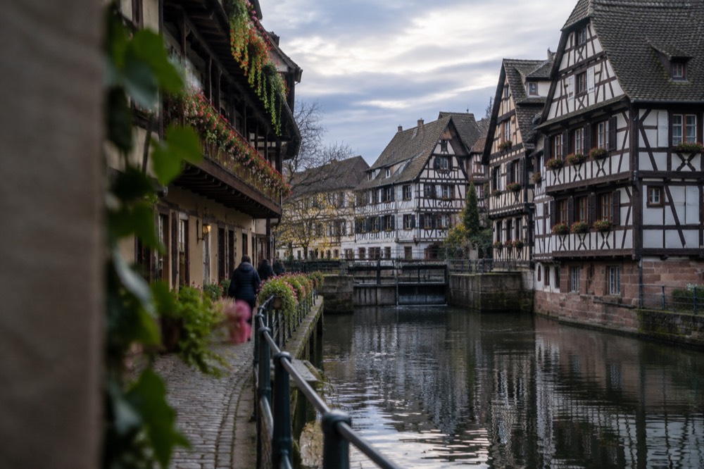 Flower-decked balconies above a narrow cobbled lane in the Petite France quarter of Strasbourg
