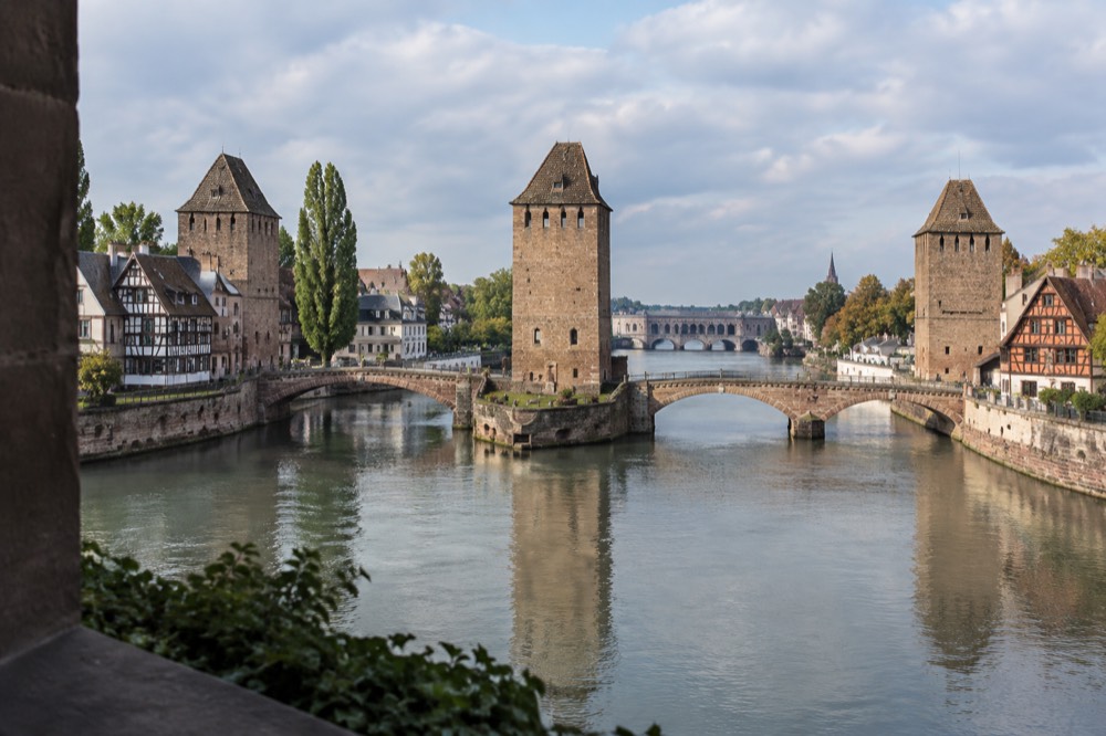 The covered bridges and the Barrage Vauban seen across the River Ill at dusk