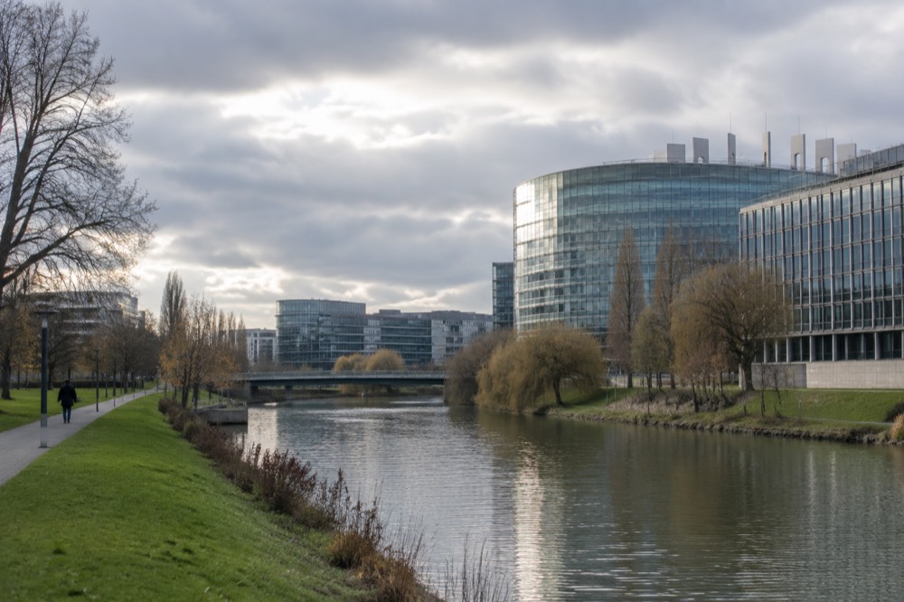 Modern glass buildings of Strasbourg's European quarter beside the Ill river
