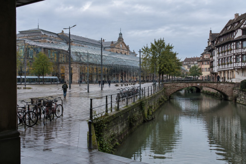Half-timbered houses beside a narrow canal crossed by a stone footbridge