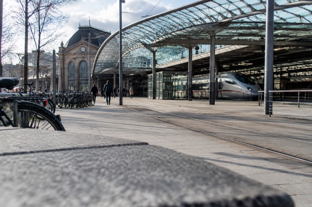A sleek high-speed train waiting at a platform under a station roof