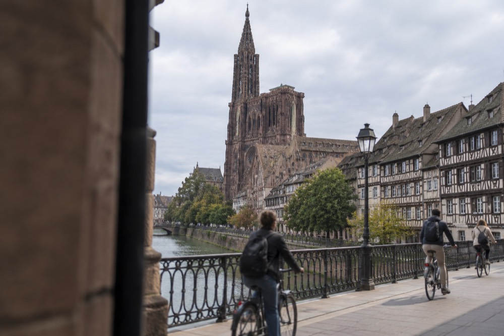 Cyclists crossing a bridge over the River Ill in central Strasbourg