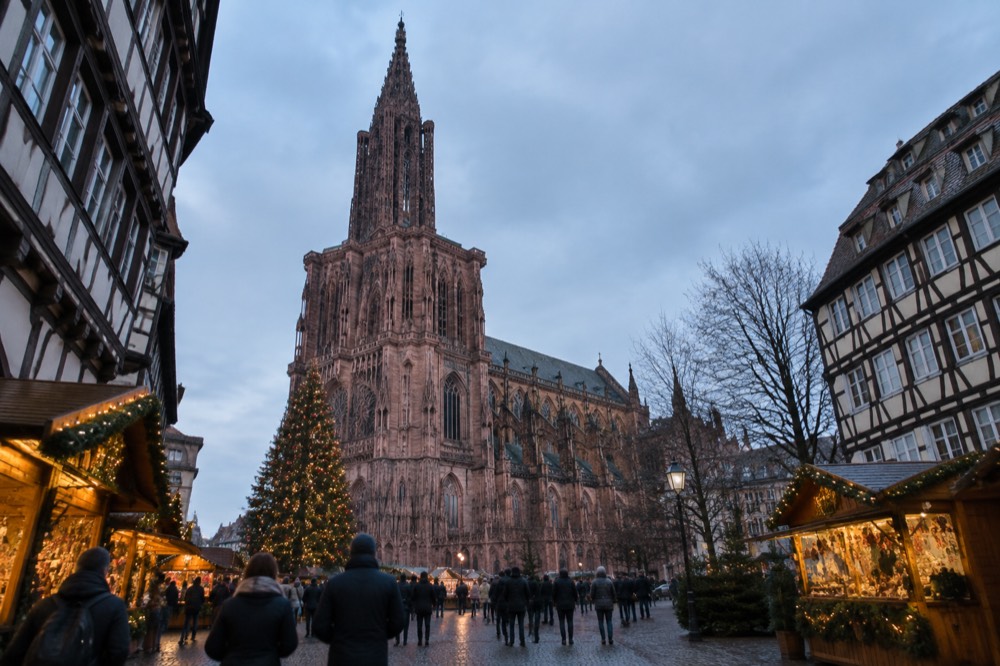 A Christmas market chalet street with lights and a decorated tree in Strasbourg