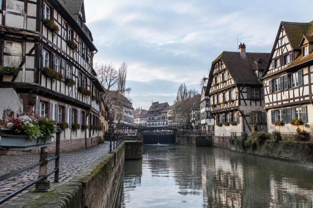 Half-timbered houses along the Ill river in Petite France on a bright morning