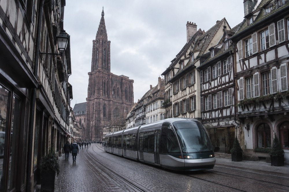 A tram passing through a street of half-timbered buildings in central Strasbourg