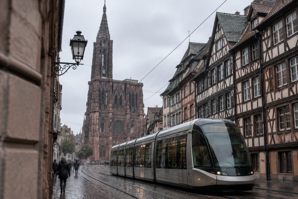A modern tram passing timber-framed buildings on a Strasbourg street