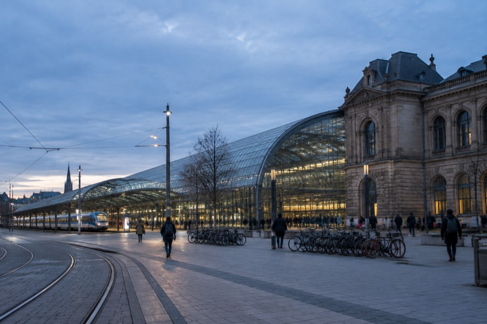 A long-distance train waiting at a platform beneath a glass station roof