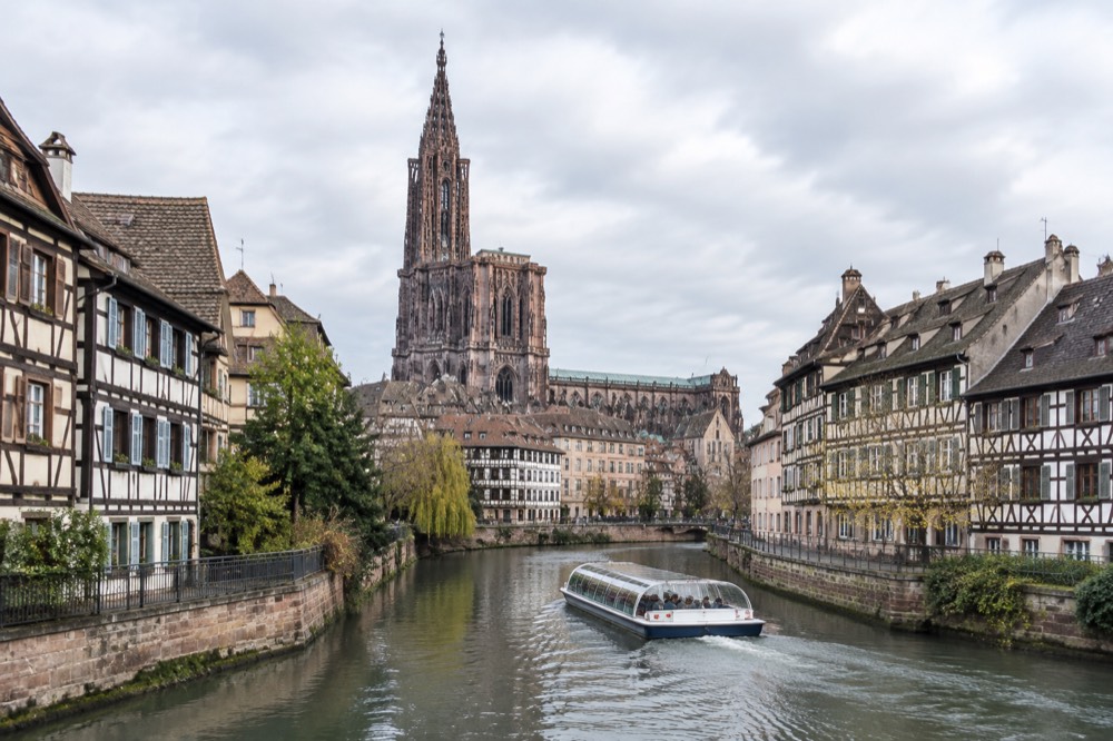 A canal boat passing half-timbered buildings on the river Ill in Strasbourg
