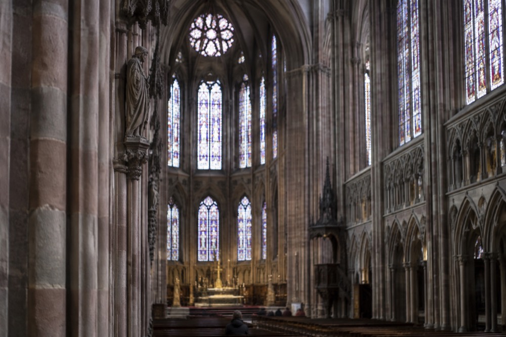 Interior of Strasbourg Cathedral with tall Gothic pillars and stained glass