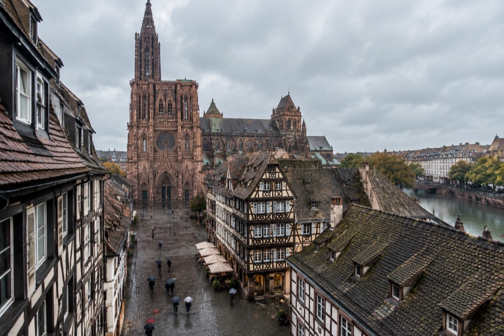 Umbrellas and wet cobblestones outside a half-timbered building in Strasbourg