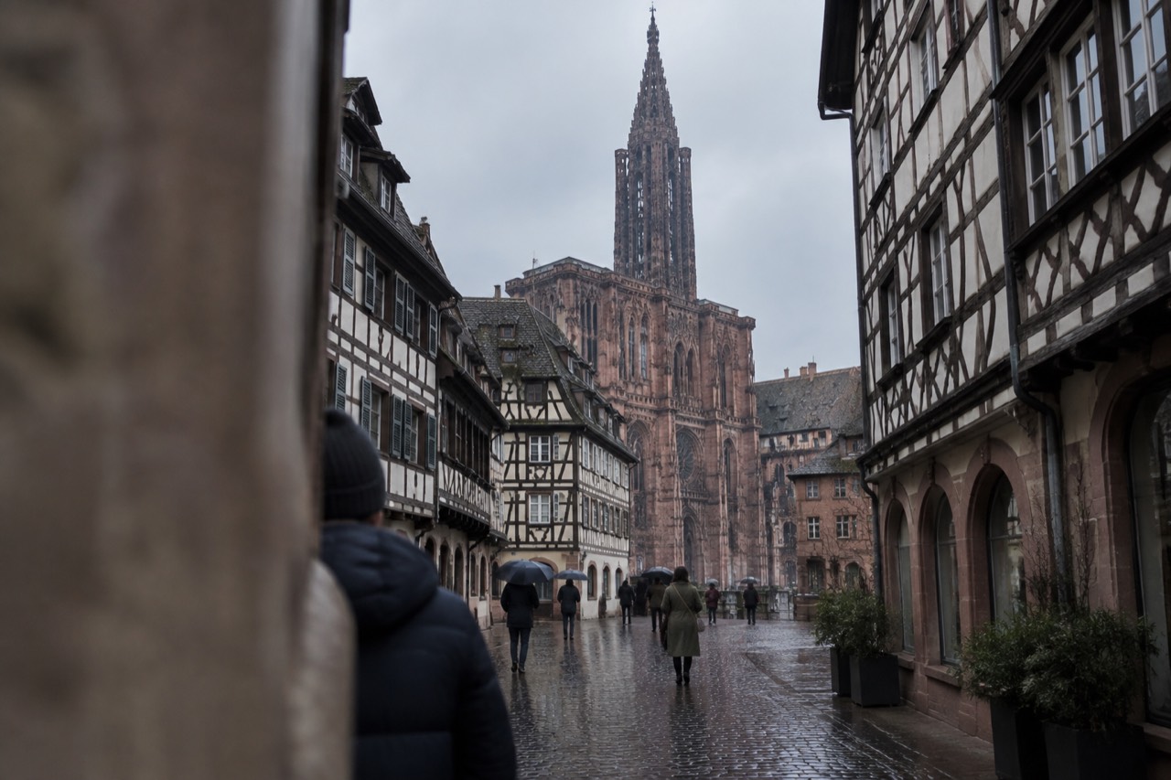 Wet cobblestone street lined with half-timbered houses in Strasbourg old town