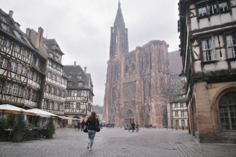 Gothic cathedral facade rising above a square with timber-framed buildings