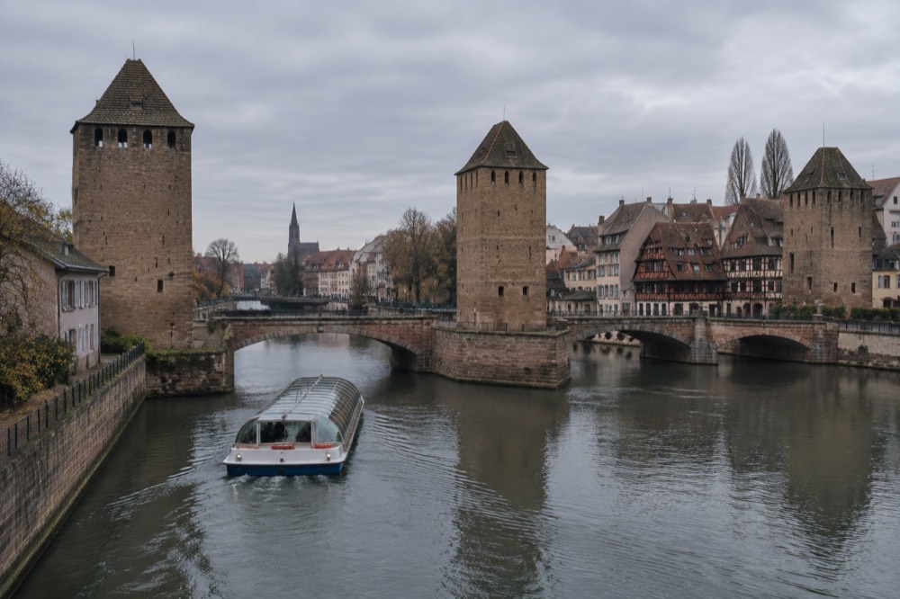 Sightseeing boat passing the covered bridges on the Ill in Strasbourg