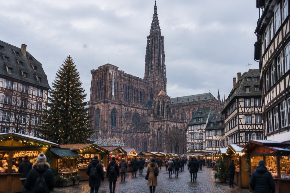 Christmas market chalets and a large decorated tree on a city square in Strasbourg