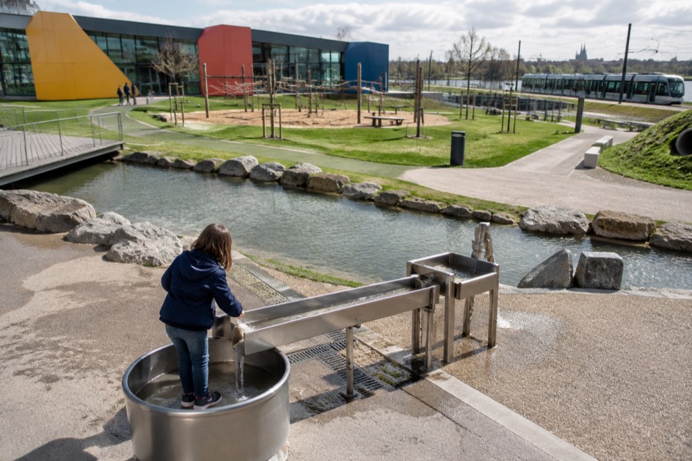 A child interacting with a water exhibit at Le Vaisseau science museum
