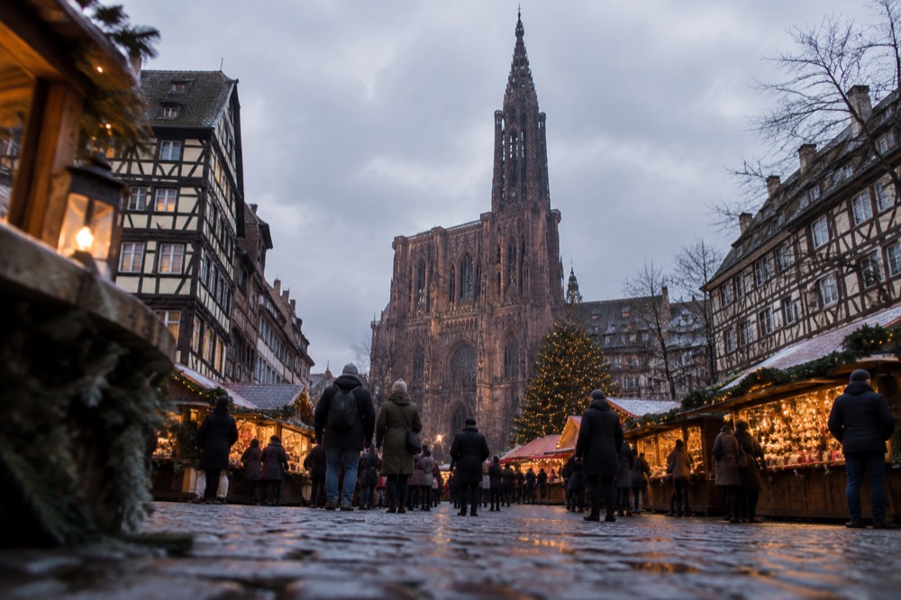 The Strasbourg Christmas market at dusk with the cathedral spire in the background